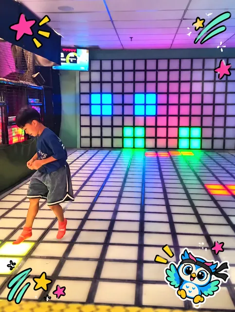 A child playing on the light-up floor grid